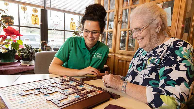 caregiver and senior playing dominoes right at home