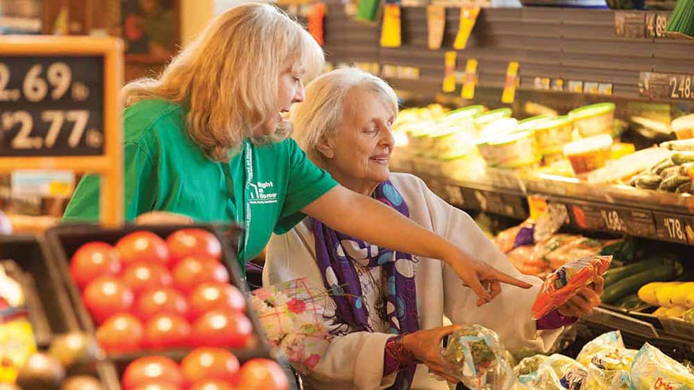 Caregiver assisting senior grocery shopping - right at home senior care