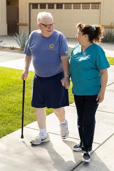 caregiver walking senior with cane