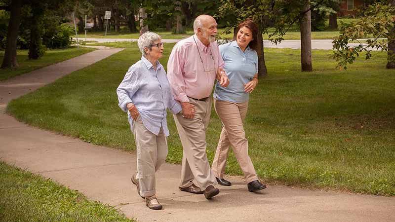 Caregiver walking seniors in park