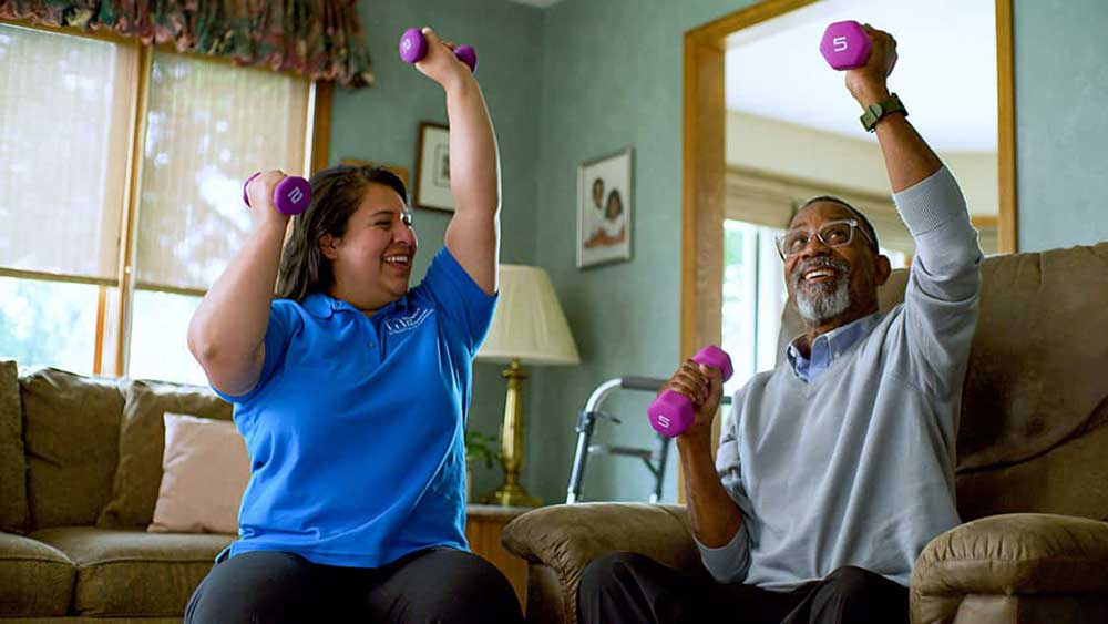 caregiver and senior lifting weights