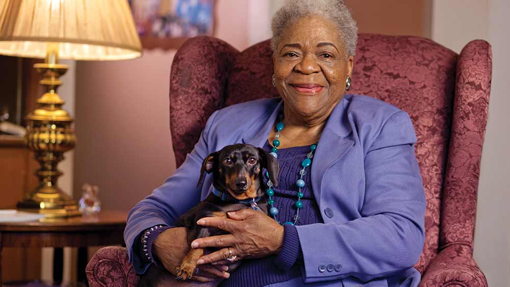 seated senior woman with dog on lap