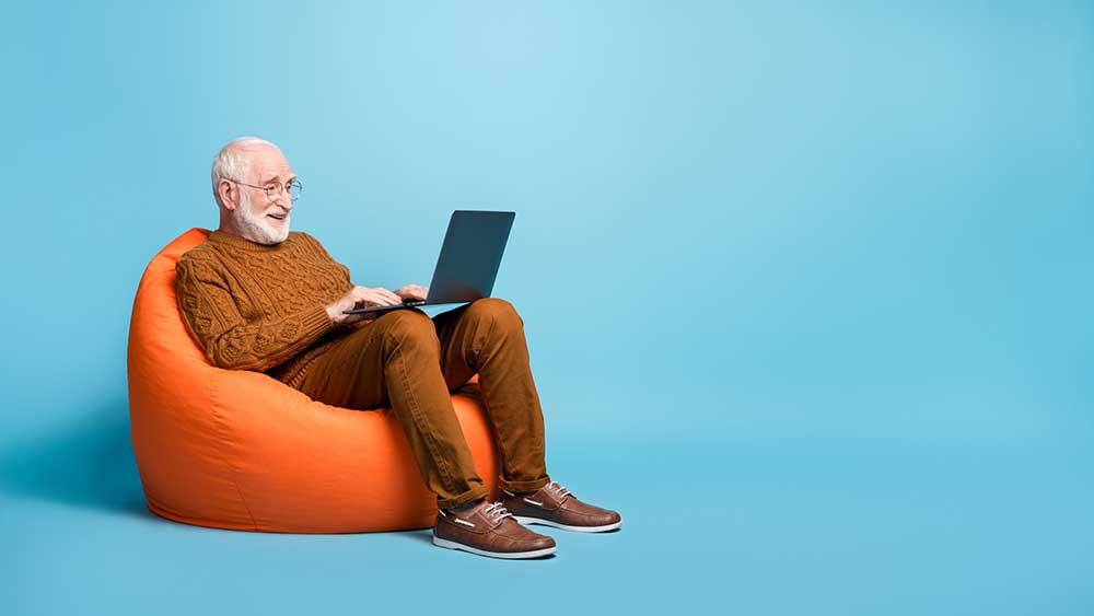 senior-in-beanbag-chair-surfing-with-laptop