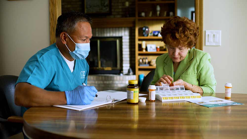 senior-and-caregiver-medication-assessment-at-table