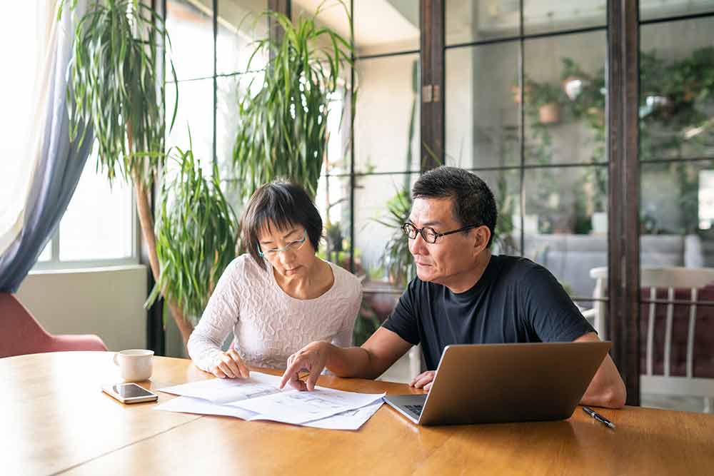 elder-couple-reviewing-documents-at-table