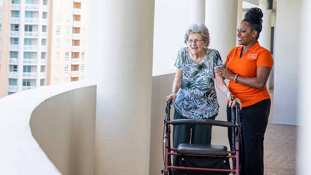 senior and caregiver standing on terrace