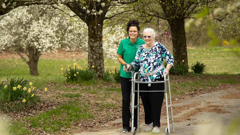 caregiver-and-senior-walking-outside-in-spring
