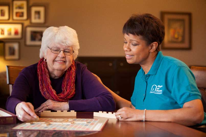 senior playing scrabble with caregiver