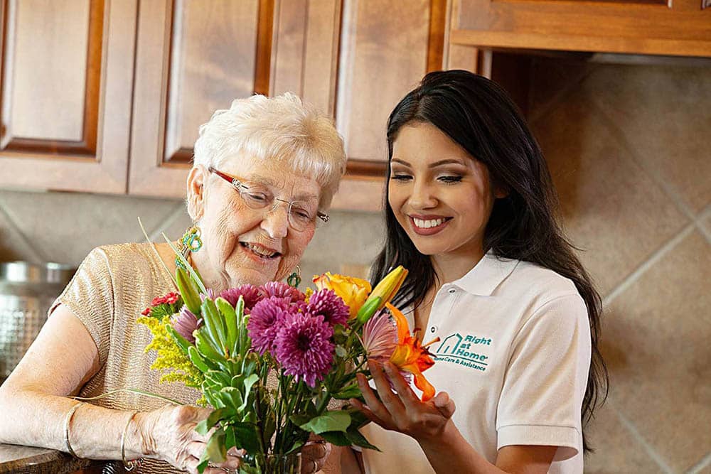 caregiver helping senior arrange flowers