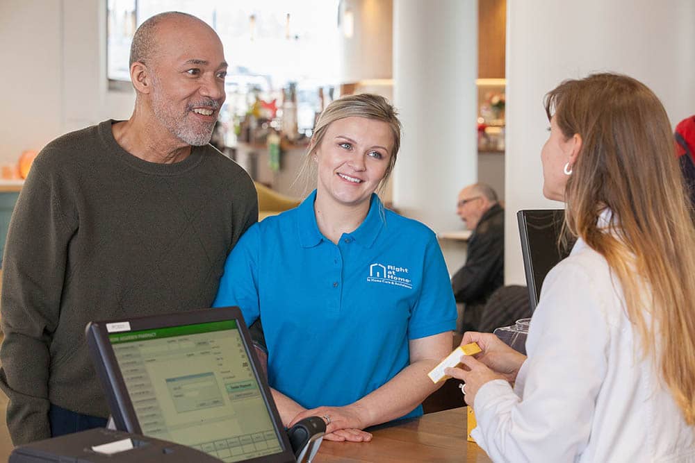 Caregiver assists senior at pharmacy