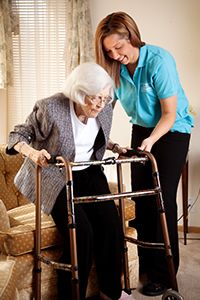 Caregiver Assists Senior with Standing