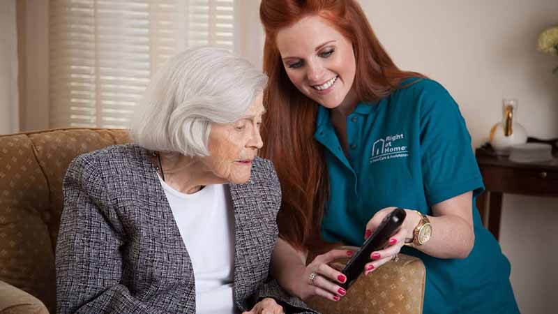 caregiver showing senior the remote control