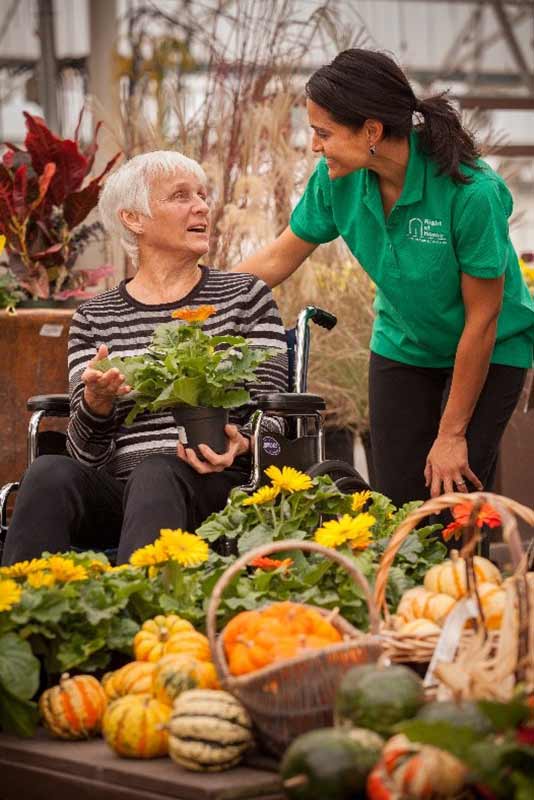 Caregiver and senior in vegetable garden