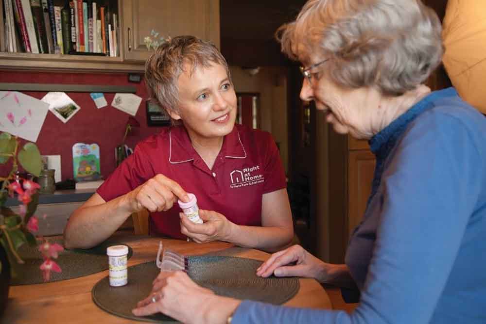 caregiver providing medication management to senior