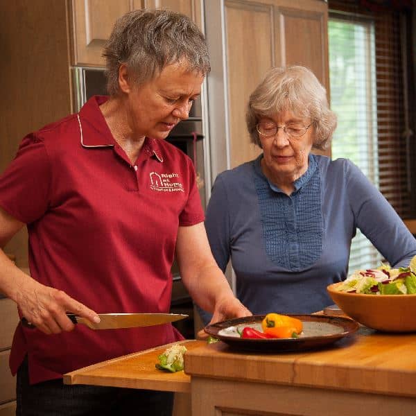 Caregiver cooking with senior