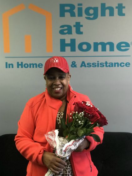 2019 Caregiver of the Year Troy Campbell with roses in front of Right at Home sign