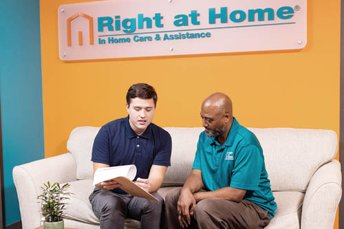 Two Men Sitting on a Couch Reviewing Care Paperwork