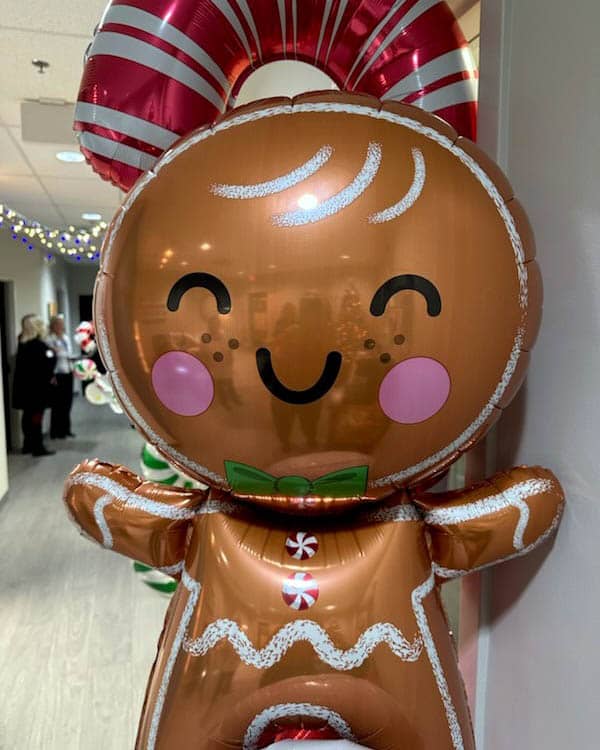 Candy cane and gingerbread cookie balloons serve as office decorations