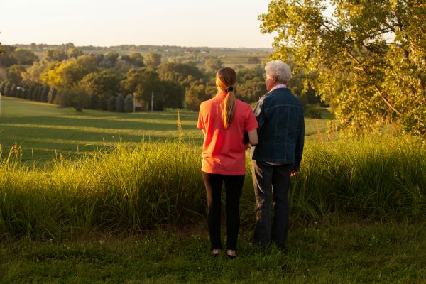 Senior woman and female caregiver standing in a field