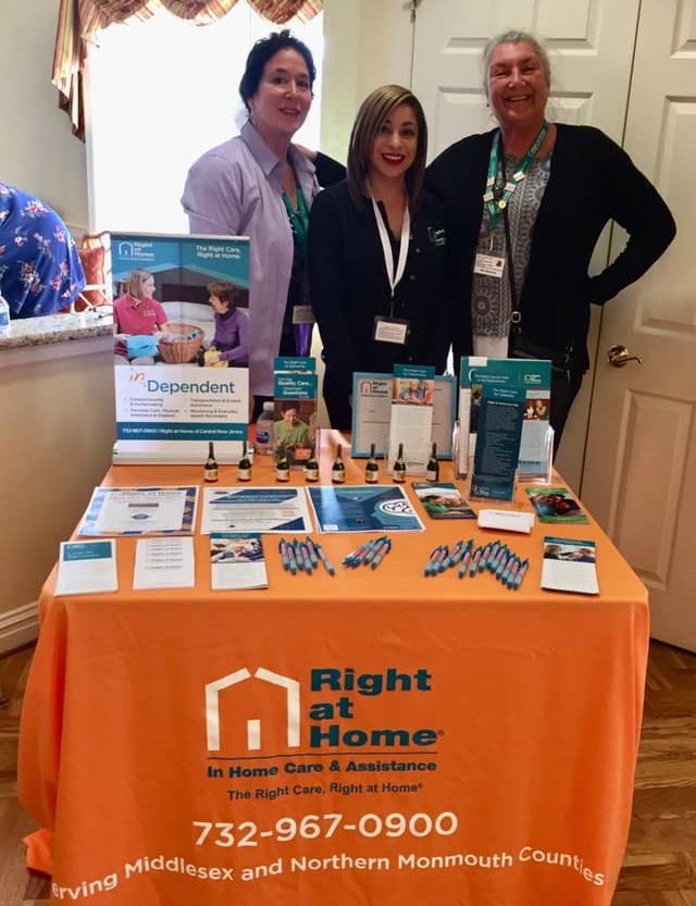 three women standing at Right at Home table