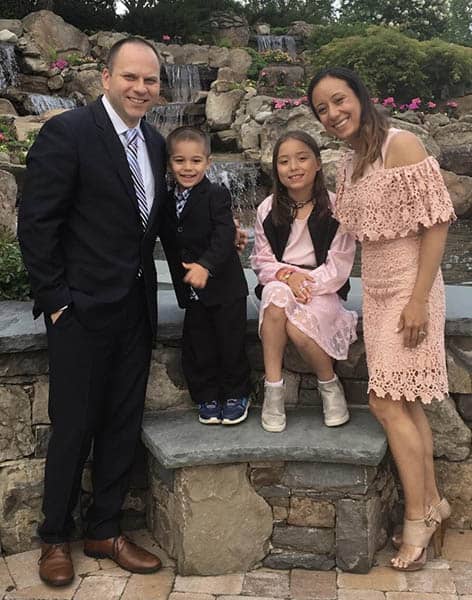 Catherine Zalewski, her husband, and two children posing for a family photo