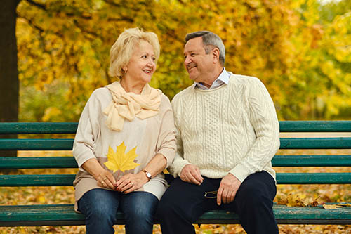 fall photo with 2 people sitting on a bench