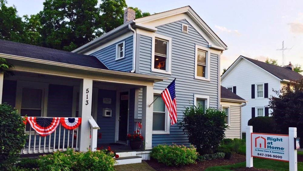 Light blue house with Right at Home signage in front yard