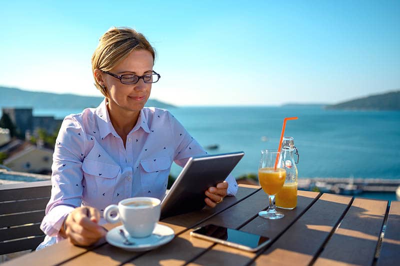 woman sitting by lake reading