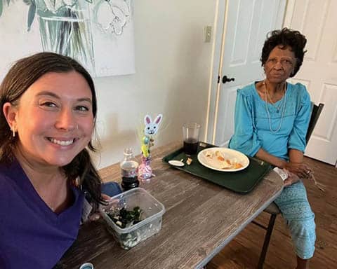 A caregiver enjoying lunch with her senior client.