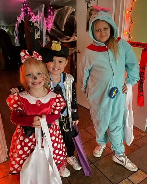 Three cute littles ones showing off their costumes for Halloween.