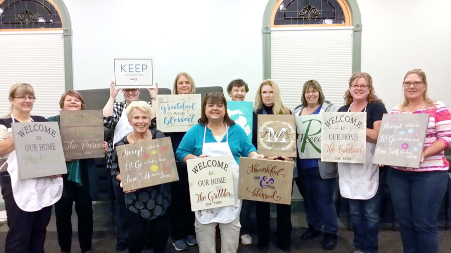 The Women's Group show off their painted pallets at the Cornerstone Church in Brooklyn, MI.