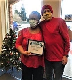 Caregiver Ineda Childers poses with Owner, Lew Myers, and her certificate.