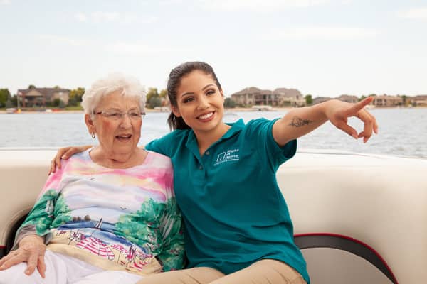 Caregiver and senior on a boat looking at the sites.