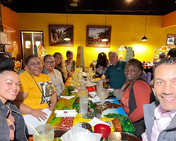 Staff and caregivers celebrating Trina at dinner