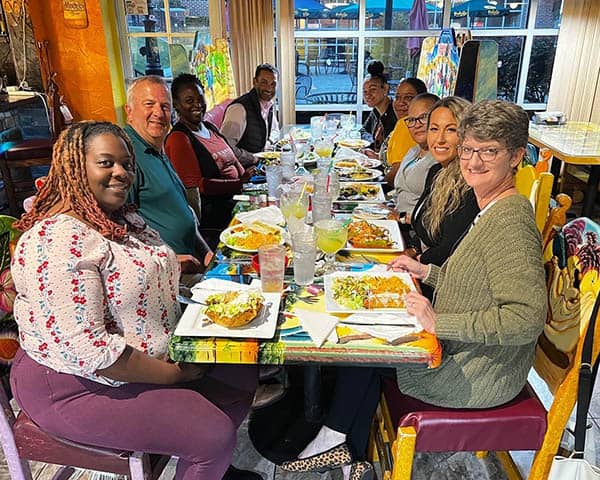 Staff and caregivers celebrating Trina at dinner table