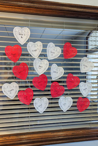 A Window with Many Handwritten Hearts Posted On It