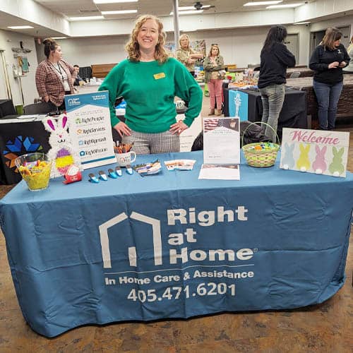 Right at Home Staffer Standing at an Event Table at the Health Fair Cushing Senior Citizen Center