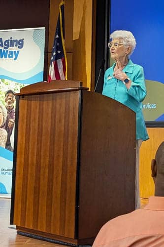 Oklahoma Department of Human Services event female speaker standing on stage behind a podium