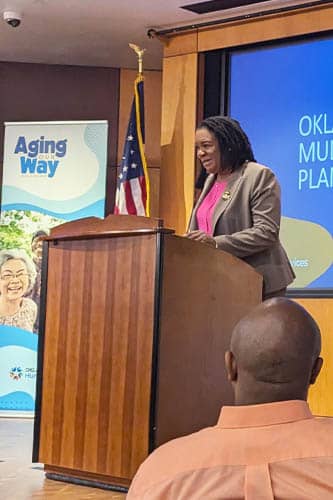 Oklahoma Department of Human Services event African-American female speaker standing on stage behind a podium