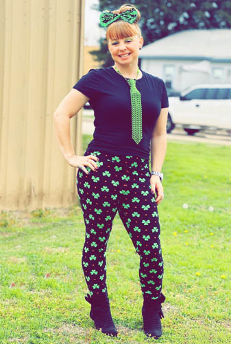 St. Patrick's Day Costume Winner Standing Outside in the Grass with a Purple Outfit and Green Tie