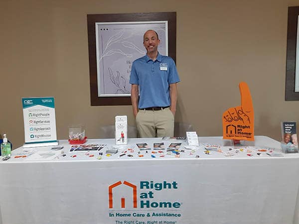 Brian from Right at Home standing behind the Right at Home booth at a Senior fair