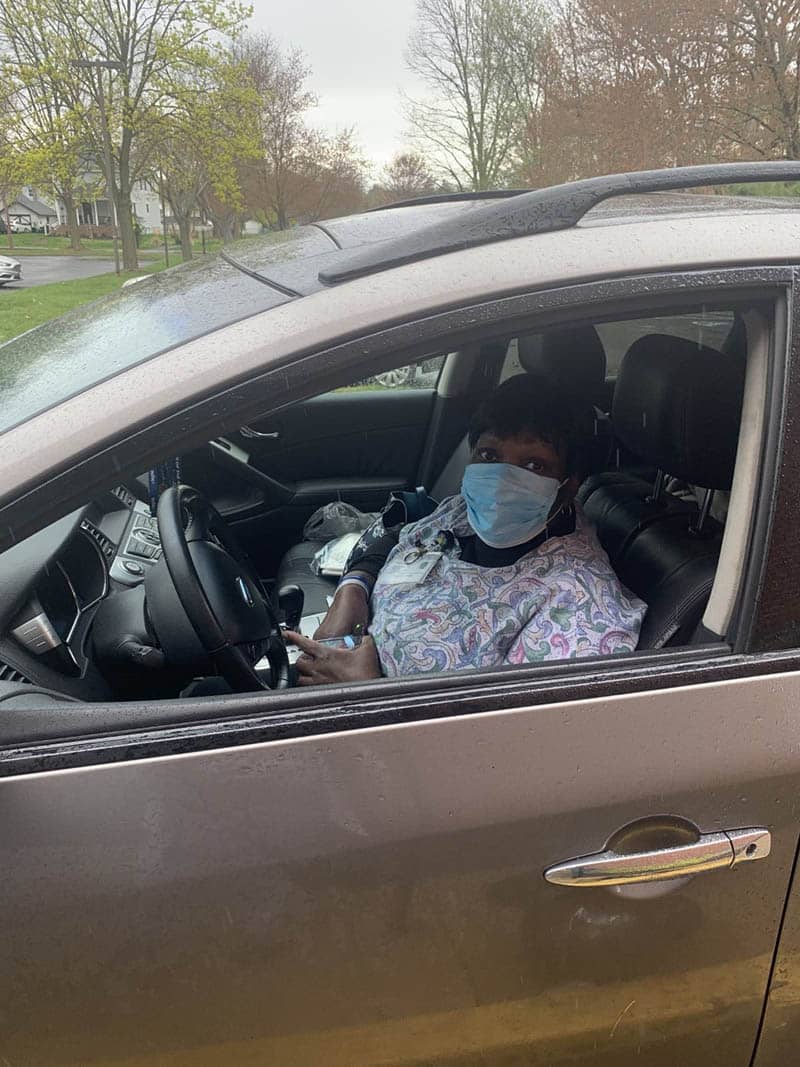 Caregiver driving to client's home in PPE