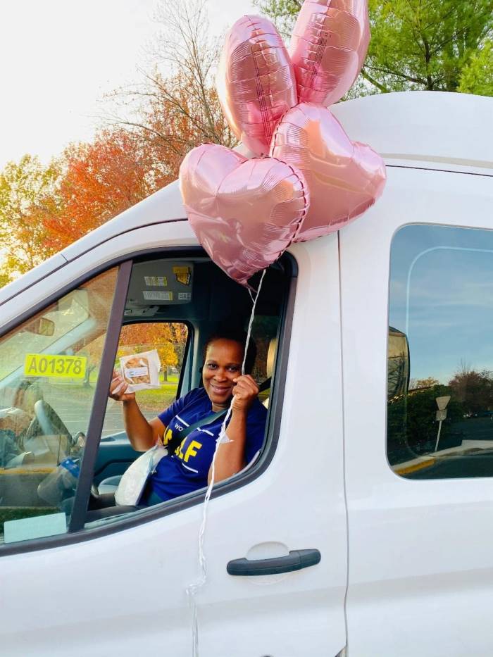 Right at Home caregiver with heart balloons.