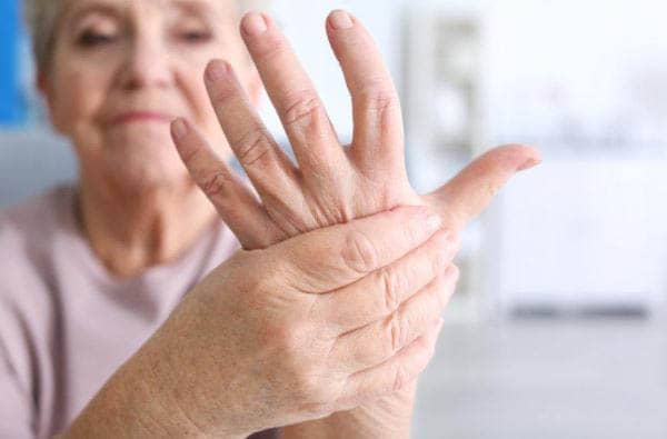 Woman with Arthritis holding her hand in pain