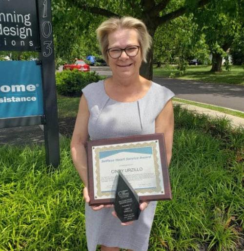 Cindy Urzillo proudly displays her Selfless Heart Service Award