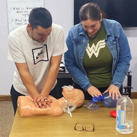 Caregiver Team Practicing CPR During Training