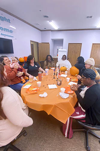 A table full of caregivers and pumpkins during a Halloween caregiver appreciation event