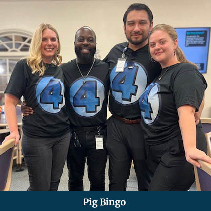 Four men and women wearing Fantastic Four t-shirts posing side-by-side