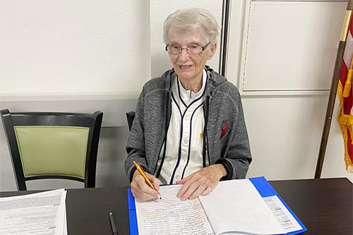 A female senior filling out paperwork for the Walgreens and Right at Home Oklahoma City Booster Clinic