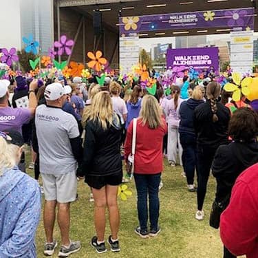 Group of Alzheimer Walk attendees watching entertainment on stage